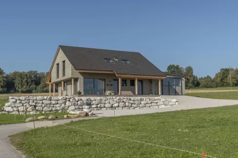 Neubau Wohnhaus mit wunderschönen Veranda im Amerikanischen-Style, Truberholz Wände sind sichtbar (mit Holzdübel sichtbar), das komplette Haus besteht aus Holz (es wurden keine Fermacel-Platten verwendet), Aussenschalung liegend - vorvergraut, ohne Kellergeschoss, dafür mit Garagenanbau direkt am Wohnhaus, das Haus ist ein Wohnhaus von einem Landwirtschaftlichen Betrieb, deshalb die integrierte Nasszone (Nassraum), der Badezimmerboden ist ein Massivholzboden aus Fichte (keine Fliessen) 