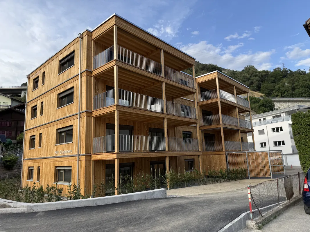 Mehrfamilienhaus in moderner Holzbauweise mit vier Geschossen, grosszügigen Balkonen und Holzfassade