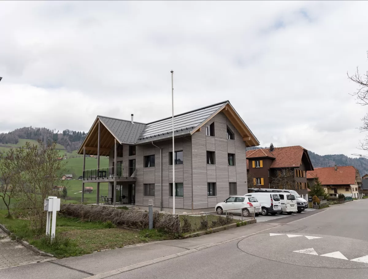 Truberholz Mehrfamilienhaus. Aussenschalung vor vergrautes Falzbrett aus Tanne, integrierte Sauna in Ferienwohnung, Saunawand aus Tanne, Möbel in der Saune aus Arven Holz, Truberholz-Wände innen sichtbar, inklusive Decke Dachschräge, Gebäudehülle Truberholz sichtbar, Innendecke Brettstapel, Boden ist alles Trockenbauaufbau, Zimmer und Bad aus Tannen Holz und allgemein Räume sind Buchenriemenboden. Türen sind alle Massivholz mit Blockfutter aus Tanne.