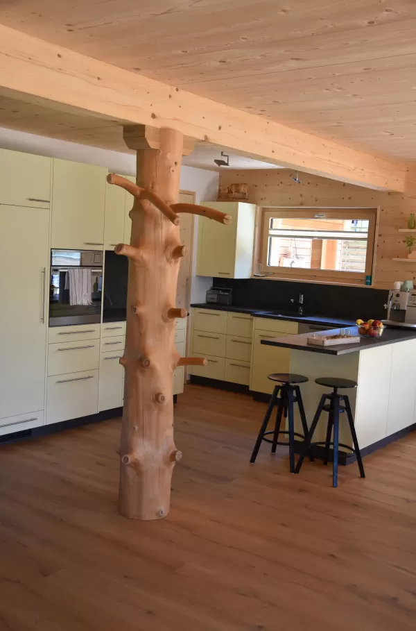 Truberholzhaus mit integriertem Baumstamm in der Küche / Wohnbereich