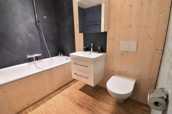 Mehrfamilienhaus in Lyss. Das Haus ist von einem Naturgarten umschlungen. Die Storen sind nach einem Farbmuster von der Bauherrin ausgewählt.