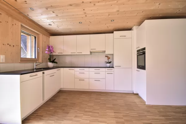 Mehrfamilienhaus in Lyss. Das Haus ist von einem Naturgarten umschlungen. Die Storen sind nach einem Farbmuster von der Bauherrin ausgewählt.