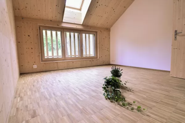 Mehrfamilienhaus in Lyss. Das Haus ist von einem Naturgarten umschlungen. Die Storen sind nach einem Farbmuster von der Bauherrin ausgewählt.