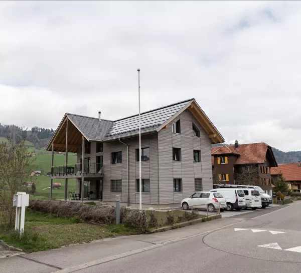 Truberholz Mehrfamilienhaus. Aussenschalung vor vergrautes Falzbrett aus Tanne, integrierte Sauna in Ferienwohnung, Saunawand aus Tanne, Möbel in der Saune aus Arven Holz, Truberholz-Wände innen sichtbar, inklusive Decke Dachschräge, Gebäudehülle Truberholz sichtbar, Innendecke Brettstapel, Boden ist alles Trockenbauaufbau, Zimmer und Bad aus Tannen Holz und allgemein Räume sind Buchenriemenboden. Türen sind alle Massivholz mit Blockfutter aus Tanne.